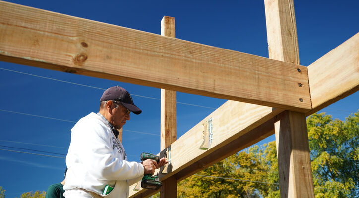 Older Hispanic Man Using a Power Drill using Ohio Post-Frame Solutions for Contractors